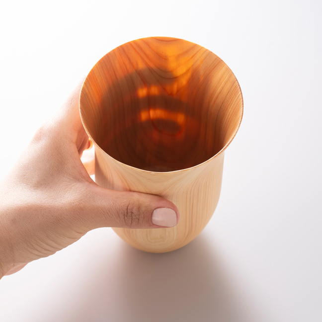 木製カップを持つ手が透けるほど薄い